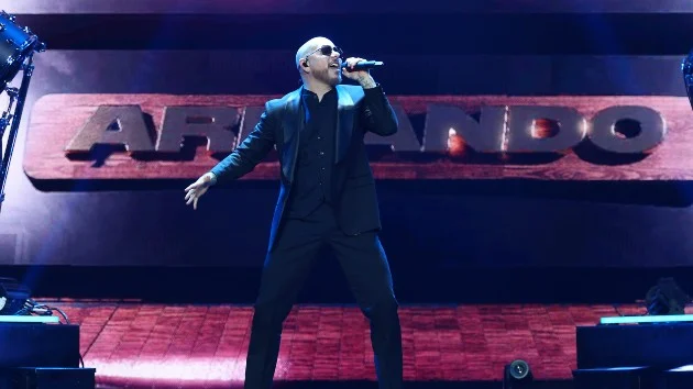Pitbull says trend of fans dressing like him in suits and bald caps is priceless